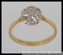 An 18ct gold and platinum vintage ladies diamond illusion flower head ring.