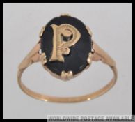 A 9ct gold gentlemans signet ring with gold letter P on black ground. Total weight 2.