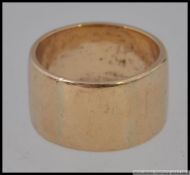 A hallmarked 9ct gold plain wide band ring Weight 9.9g. Size N.