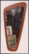 A 1970's retro teak Atomic style wall mirror of angular form with teak back plinth and frameless