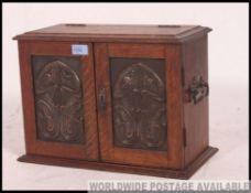 An early Victorian arts and crafts smokers cabinet with handles to sides.