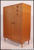 A 1960's retro upright blond oak pedestal tallboy chest of drawers by Meredew.