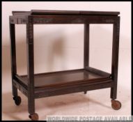 A Chinese metamorphic hardwood mid century butlery serving trolley.