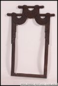 A Victorian mahogany mirror frame in the form of theatrical curtains being drawn back on rails