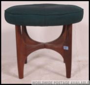 A stunning 1970's G-Plan teak wood dressing table stool of circular form being raised on teak