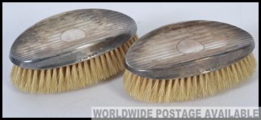 A pair of leather cased silver hallmarked gentlemen's hair brushes,