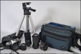 A vintage Canon AV-1 slr camera together with a Canon Hoya lens and another,