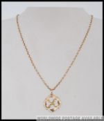 A 9ct gold chain link necklace with barrel push clip clasp strung with a 9ct gold Art Nouveau