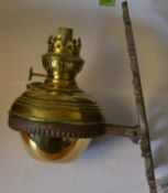 A Victorian cast iron door architectural wall mounted brass oil lamp with large ring supporting the
