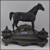A cast bronze inkwell in the form of a horse on an ornate base with hinged inkwells,