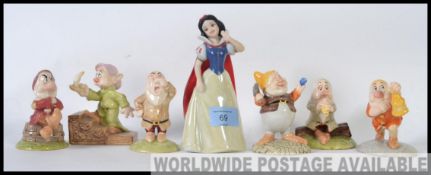 A collection of Snow White & 7 Dwarves figurines to include Snow White, Dopey with Candlelight,