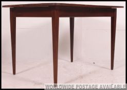 A retro 1970's teak wood dining table raised on extending frieze frame with central additional leaf.