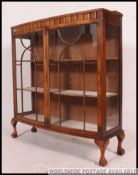 A 1930's Art Deco walnut bow front china display cabinet raised on cabriole legs with ball and claw