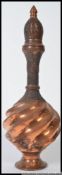 An Indian copper decorative twist design shaped bottle.