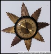 A retro 1970's sunburst wall clock with gilded facia together with a still boxed 1970's retro wall