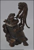 A cold painted bronze of a monkey pulling a tooth from a hippo L7cm