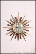 An original retro vintage 1970's Metamec sunburst wall clock with faux wood and brass spikes.