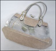 A retro designer 1970's clear plastic and canvas strapped ladies handbag having glass finial twist