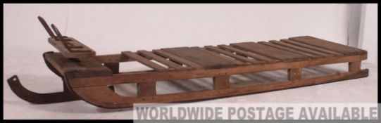 Traditional wooden early 20th century Husky sledge, with iron 'steering blade' to front.