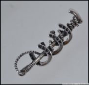 A 925 silver bar brooch with lucky horseshoes entwined on a horse whip.