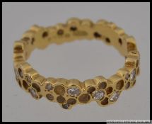 A hallmarked 18ct gold honeycomb diamond band ring set with approx 30pts of graduated diamonds in a