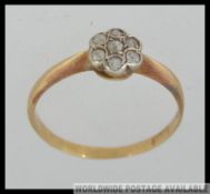 An 18ct gold and platinum vintage ladies diamond illusion flower head ring.