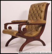 A mahogany and green leather chesterfield armchair.