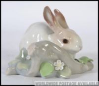 A Lladro ceramic Figure group of a Rabbit in a naturalistic setting by a Branch W11cm