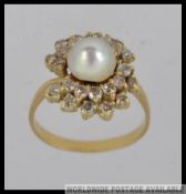 An 18ct gold diamond and pearl ladies cluster ring with central pearl. The diamonds approx 1.