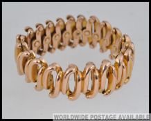 A designer yellow metal articulated expanding bracelet (tests for 9ct) with expanding links marked