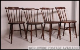 A set of 4 Victorian beech and elm windsor dining chairs raised on turned legs with circular seats