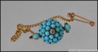 An Edwardian yellow metal brooch set with turquoise beads and a central diamond in a star setting