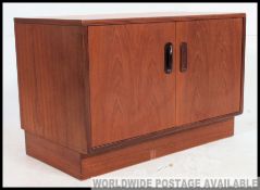 A retro G Plan fresco entertainment sideboard of small proportions withy a pair of hinged doors to