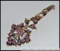 A stunning ladies ruby on gilt silver necklace pendant in the form of a floral spray bouquet.