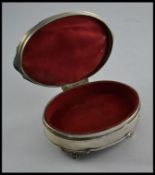 A silver hallmarked ladies jewellery trinket box raised on decorative feet having hinged top and