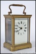 An early 20th century brass carriage clock having enamelled dial and escapement window atop.