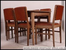 An original Gordon Russell walnut extending dining room table together with a set 5 dining chairs