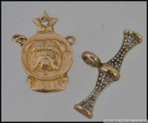 Two 9ct gold pendants one set with a bulldog emblem set with a diamond hallmarked for Birmingham