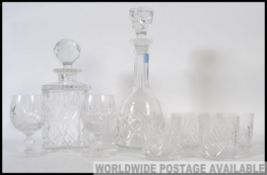 Two 20th century cut glass decanters with stoppers along with a set of four matching cut glass