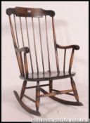A contemporary antique style windsor rocking chair on sleigh runners with shaped elbow rests and