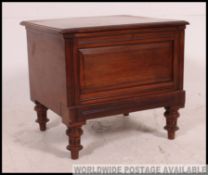A late Victorian mahogany commode raised on turned legs with hinged top and ceramic lined interior