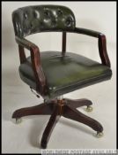 A 20th century antique style green leather and mahogany office swivel chair.