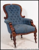 A Victorian mahogany spoon back armchair of large form with blue button backed upholstery to the