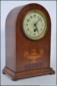 An Edwardian mahogany inlaid dome top mantel clock with decorative face with brass movement
