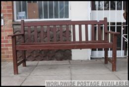A 20th century wooden garden bench with slatted seat and back rest with elbow supports.