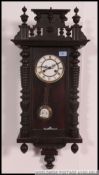 An early 20th century mahogany vienna regulator wall clock with drop dial pendulum and enamel face