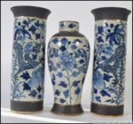 2 Chinese blue and white cylindrical salt glazed vases stylised with foliates and dragons together