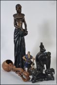 A collection of items of African and Asian form to include a tall Leonardo figure of an African