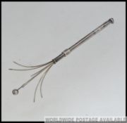 An early 20th century silver telescopic cocktail twizzle stick with extending end.