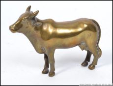 A good 19th century Indian brass figurine of a cow having central seam with the back leg stamped `B.